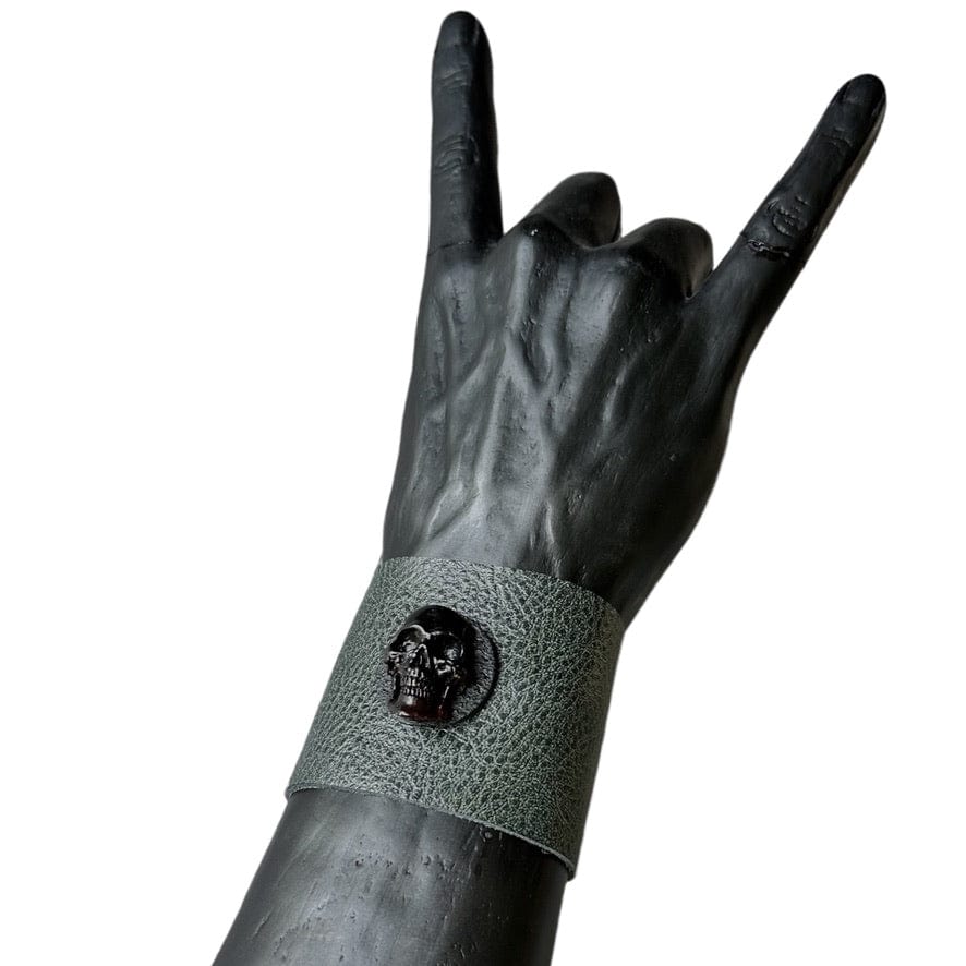 • Wornstar Custom Stage Wear Collection• Custom leather wrist band• Ready to Ship. • Designed, made, and sold exclusively by Wornstar Clothing• Individually made; each one will vary slightly• Made with soft, thick, leather• Drab, dark, olive green color• Hand-set black, distressed, metal skull• Hand-distressed•